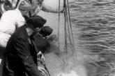The TITAN trailer diving bell has descended in the water and the U-133 diving has begun. In the picture are the dive marshal, who communicates by phone with the diver, crew members of the Italian tug and German Kriegsmarine sailors, who assist the operation. Archive Axel Urbanke U-boot im focus.