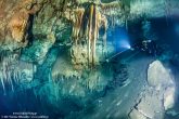 Very close to the entrance, the first stalactite formations appear. We can notice the fast declination of the cave.  Wetklik.gr (Underwater Photography by Milonakis Κostas)